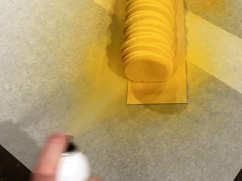 Pulvérisation du colorant en spray effet velours jaune sur la deuxième extrémité de la bûche