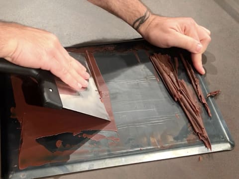 Formation de copeaux de chocolat noir à l'aide d'une spatule à chocolat