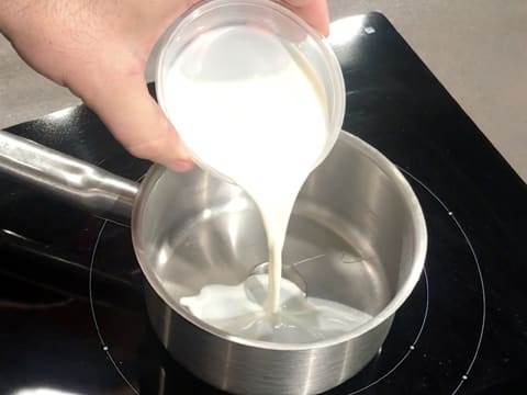Le lait est versé sur le sirop de glucose dans une casserole
