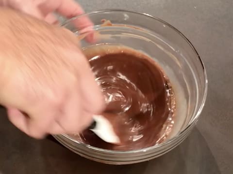 Le lait est incorporé dans le chocolat fondu à l'aide de la spatule maryse