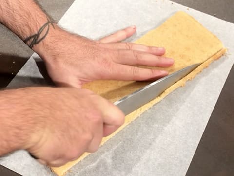 Les bords du biscuit financier sont coupés avec un couteau