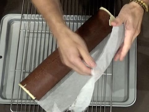 La bûche est démoulée sur la grille à pâtisserie posée sur la plaque creuse