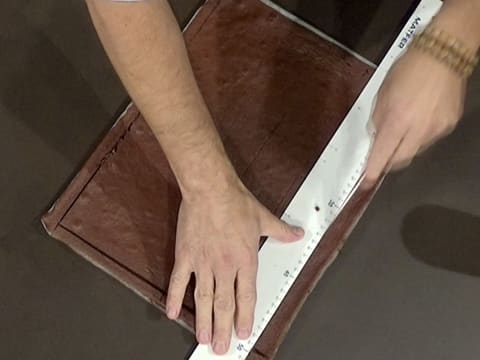 Le tour du biscuit chocolat est taillé avec un couteau et une règle graduée