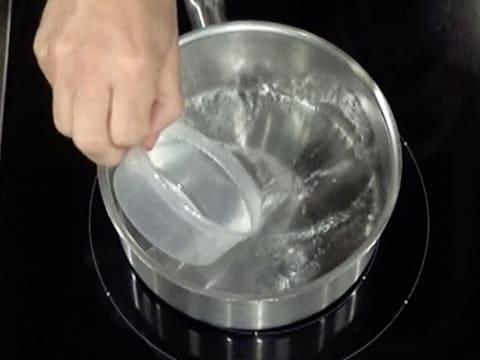 L'eau est versée dans une casserole qui est placée sur la plaque de cuisson