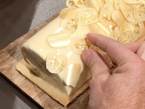 À la fin de la bûche les pastilles de chocolat blanc dorées et pailletées sont déposées de manière clairsemée