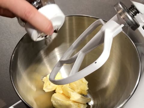 Ajout d'un peu de vanille en poudre sur le beurre pommade dans la cuve du batteur