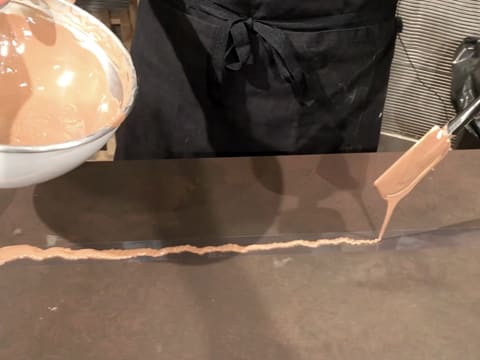 Un peu de chocolat au lait fondu est versé sur la bande de ruban pvc