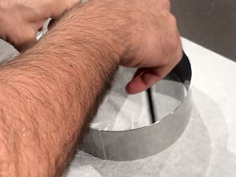 Les contours intérieurs du cercle à vacherin sont dessinés avec un crayon à papier sur une feuille de papier sulfurisé