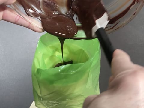 Le chocolat noir tempéré est versé dans une poche à douille