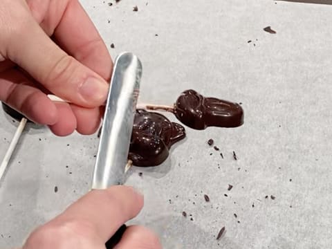 Raclage à la spatule coudée, du bâton de la sucette en chocolat