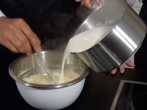 Le lait bouillant est versé sur la préparation dans le cul de poule, le tout étant mélangé au fouet