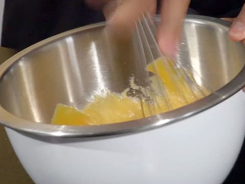 La préparation à base d'oeufs et de sucre est fouettée dans le cul de poule