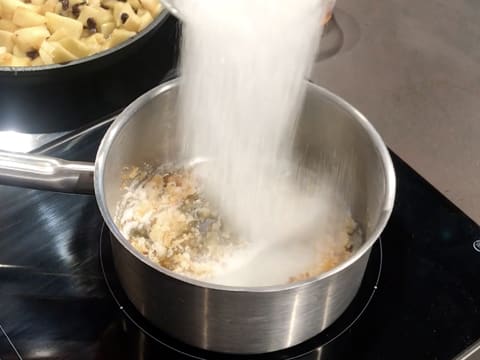 Ajout du restant de sucre en poudre en pluie fine dans la casserole