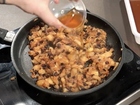 Ajout du Calvados sur la compote de pommes cuite, dans la poêle