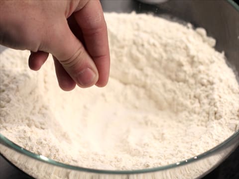 Le sel fin est versé dans la farine mise en fontaine, dans le saladier