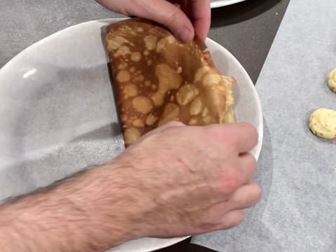 La crêpe est pliée en deux sur une assiette