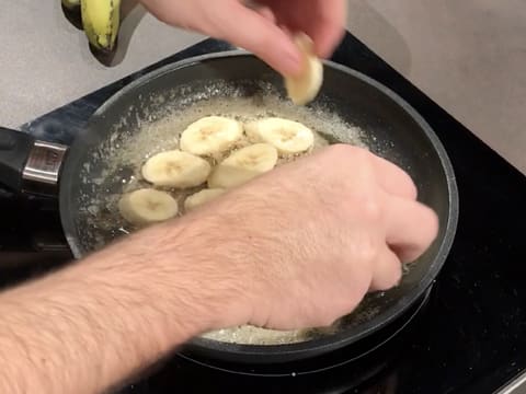 Les rondelles de banane sont disposées dans le caramel blond, dans la poêle