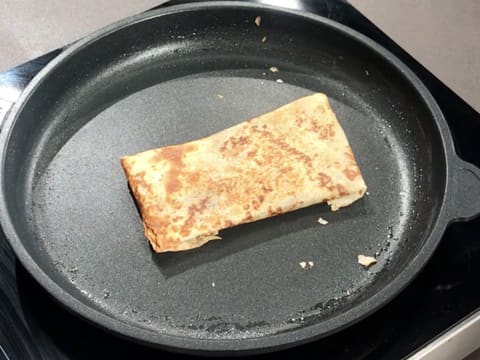 La crêpe est en train de cuire sur l'autre face dans la poêle