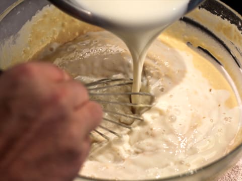 Ajout du lait sur le mélange dans le saladier