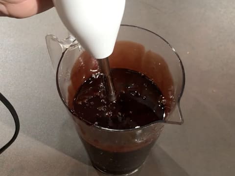 Le glaçage chocolat qui se trouve dans le pichet verseur est mixé à l'aide du mixeur plongeant