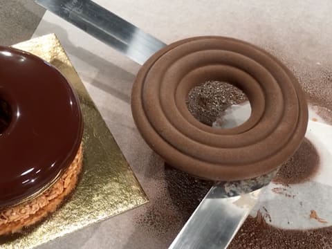 Le crémeux chocolat est soulevé avec deux spatules métalliques coudées