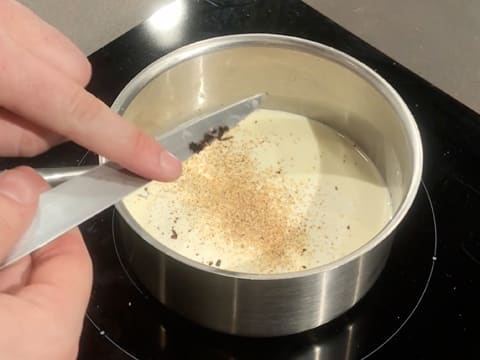 Ajout des grains de vanille qui ont été prélevés au couteau, dans la casserole contenant la crème liquide