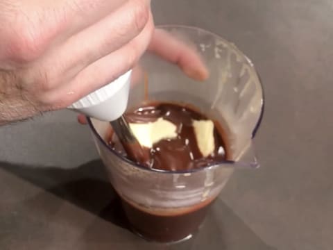 Ajout et mixage du beurre dans la préparation chocolatée dans le pichet verseur