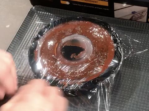 Le moule silicone et l'entremets sont filmés au contact avec une feuille de papier film