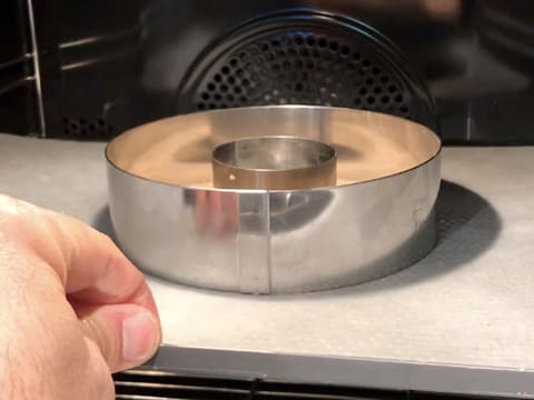 L'anneau de pâte à streusel dont les deux cercles à mousse sont positionnés autour et au centre de ce dernier, est placé dans le four