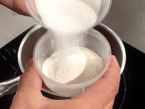 Le sucre en poudre est versé sur la pectine NH nappage dans un petit récipient