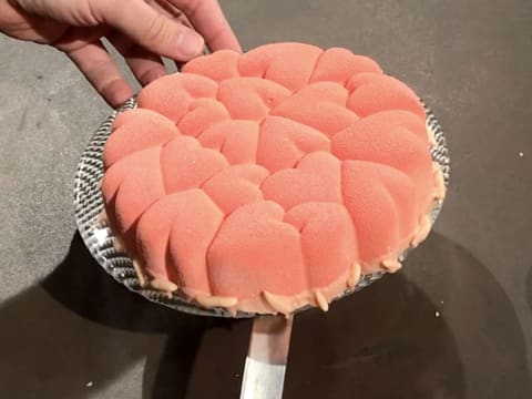 L'entremets décoré est placé sur le plat de service