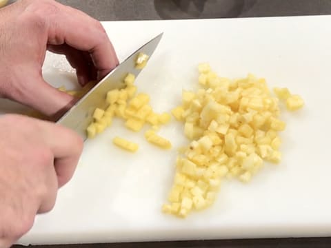 L'ananas et la mangue sont taillés en petits cubes sur une planche à découper avec un couteau