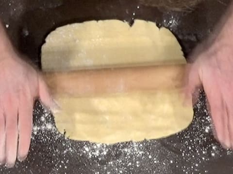 La pâte brisée à foncer est abaissée à l'aide du rouleau à pâtisserie