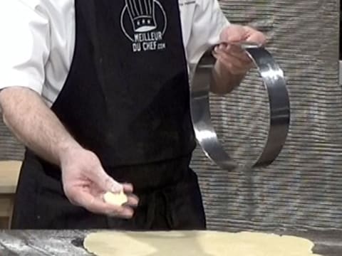 Un cercle à mousse est présenté dans une main, et une noix de beurre dans l'autre main