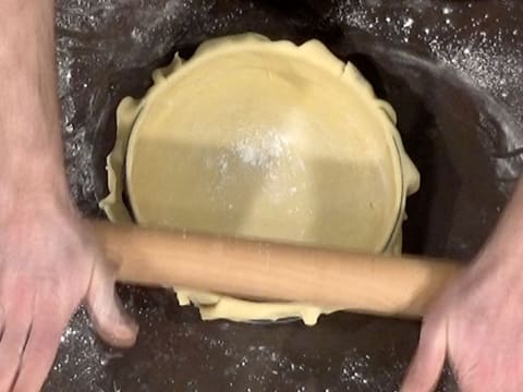 L'excédent de pâte qui dépasse du cercle à mousse, est coupé avec le passage du rouleau à pâtisserie