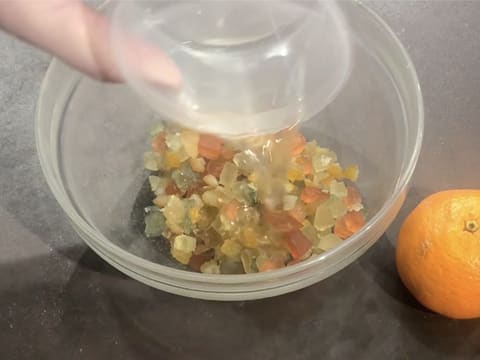 L'arôme de fleur d'oranger est versé sur les cubes de fruits confits dans un bol