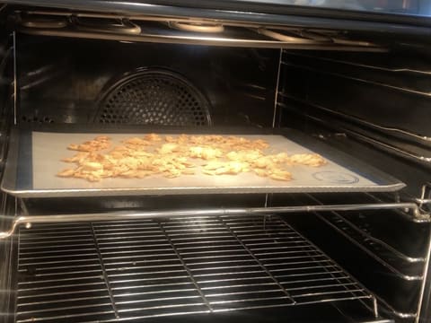 Obtention d'amandes effilées dorées dans le four à mi hauteur sur une plaque à pâtisserie recouverte d'un tapis de cuisson en silicone