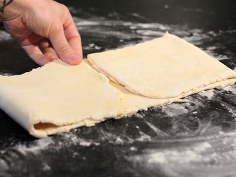 Le quart inférieur de la bande de pâte est replié vers le haut