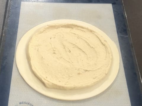 Obtention d'un disque de pâte feuilletée inversée sur lequel se trouve une couche de crème frangipane lisse et uniforme avec une petite bordure sur tout le pourtour