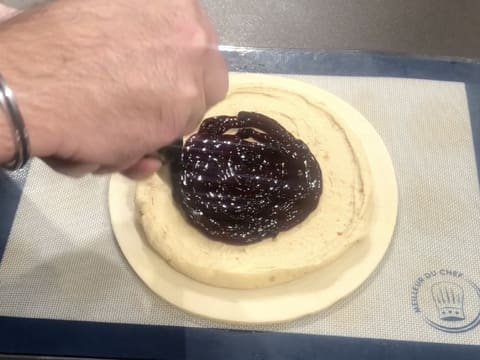 Le confit de cassis est poché en spirale sur la crème frangipane qui se trouve sur le disque de pâte feuilletée inversée