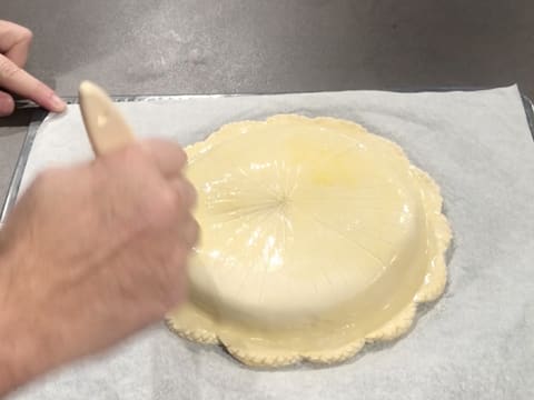 Toute la surface de la galette des rois est badigeonnée de dorure à l'aide du pinceau à pâtisserie