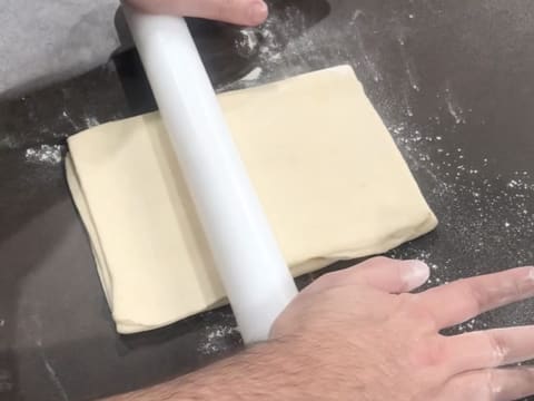 Le rectangle de pâte est abaissé au rouleau à pâtisserie sur la longueur et sur le plan de travail fleuré