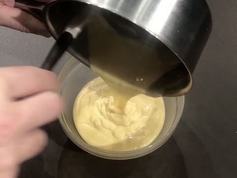 La crème pâtissière noisette est débarrassée dans un saladier qui est posé sur le plan de travail