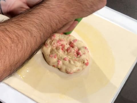 La crème frangipane à la praline rose est pochée sur la pâte feuilletée, au centre du cercle de dorure