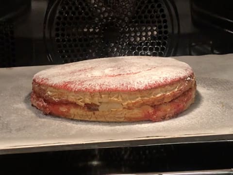 La galette saupoudrée de sucre glace et de sucre en poudre, est placée dans le four