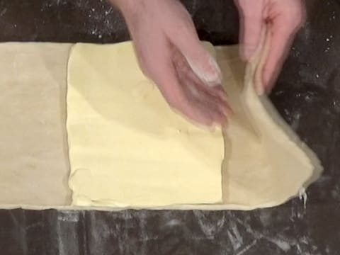 Un des côtés de la pâte est rabattu vers le centre, sur le beurre aplati