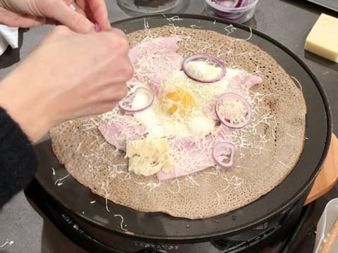 Ajout de fines lamelles d'oignon rouge sur la galette