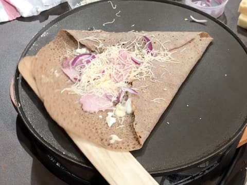 Le dernier côté de la galette est soulevé par la spatule en bois