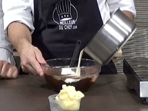 La crème contenue dans la casserole est versée dans le saladier, sur la préparation chocolatée