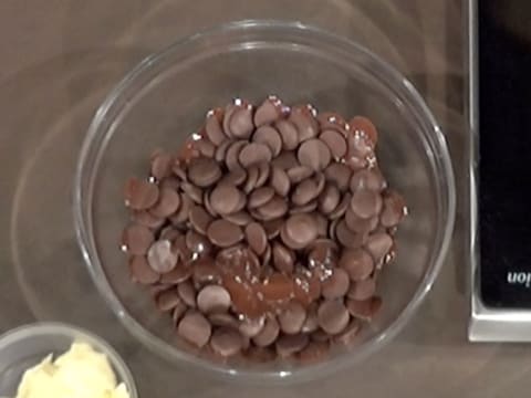 Les pistoles de chocolat noir sont partiellement fondues dans le saladier